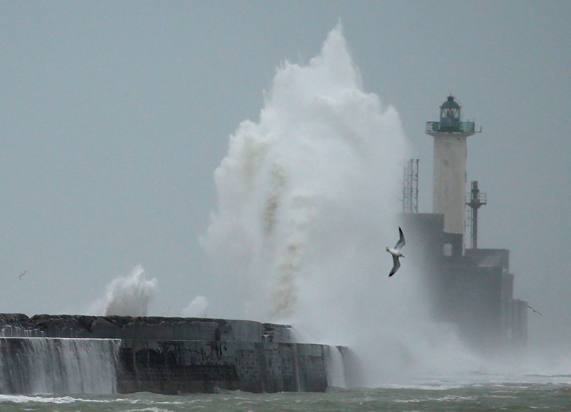 Waves crash against a lighthouse during Storm Ciara at Boulogne-sur-Mer