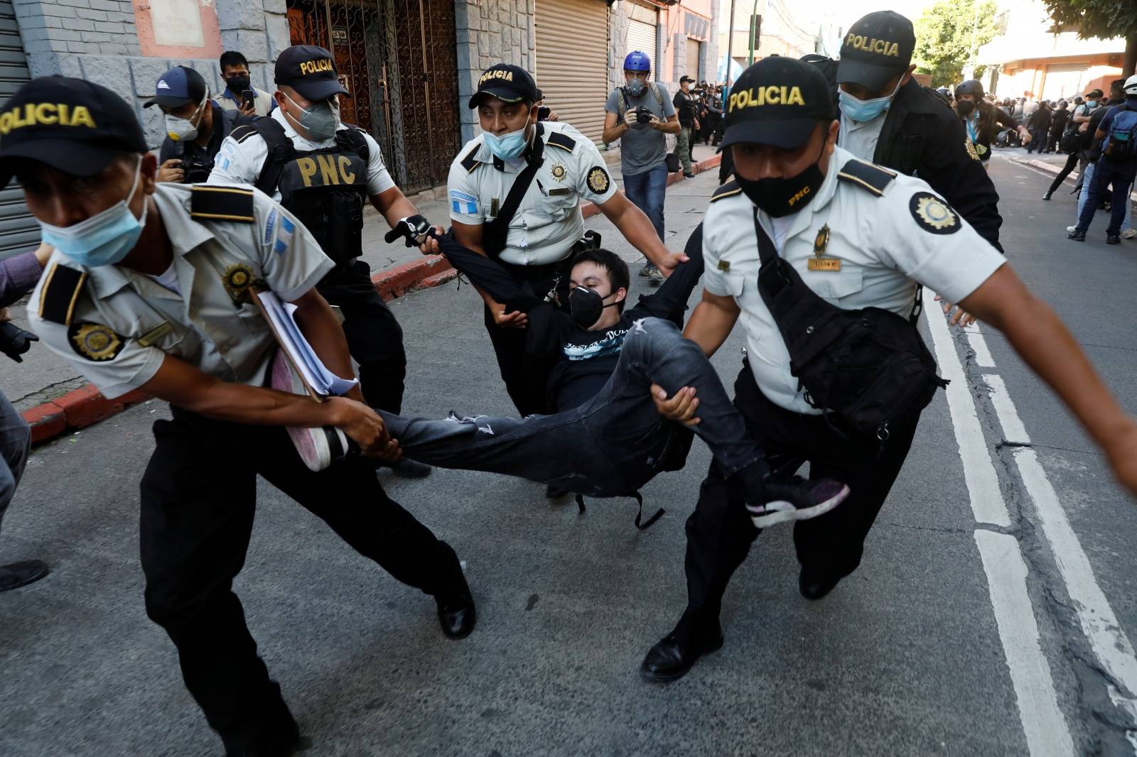 Police officers carry a demonstrator taking part in a protest demanding the resignation of President Alejandro Giammattei, in Guatemala City