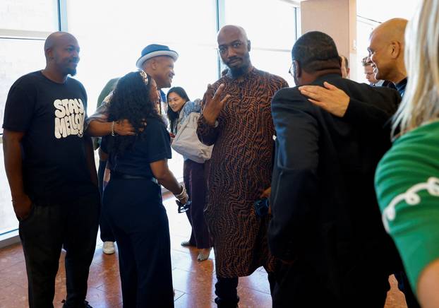 Friends and family members of rapper Tupac Shakur, and Darryl Harper, who says he is Shakur's music producer, celebrate outside a courtroom after a jury found Duane Davis guilty in the 1996 killing of Shakur