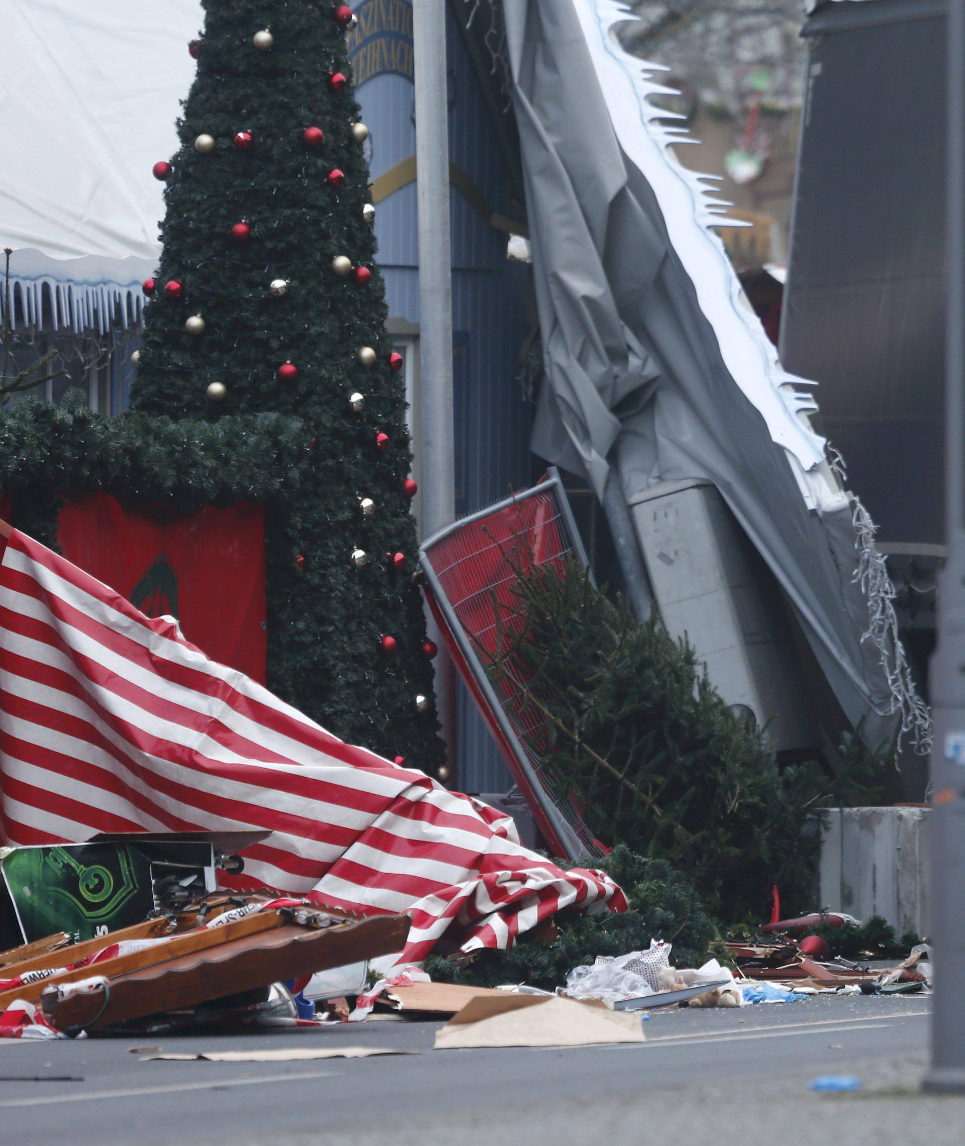 Police and fire fighters stand beside the truck which ploughed last night into a crowded Christmas market in the German capital Berlin