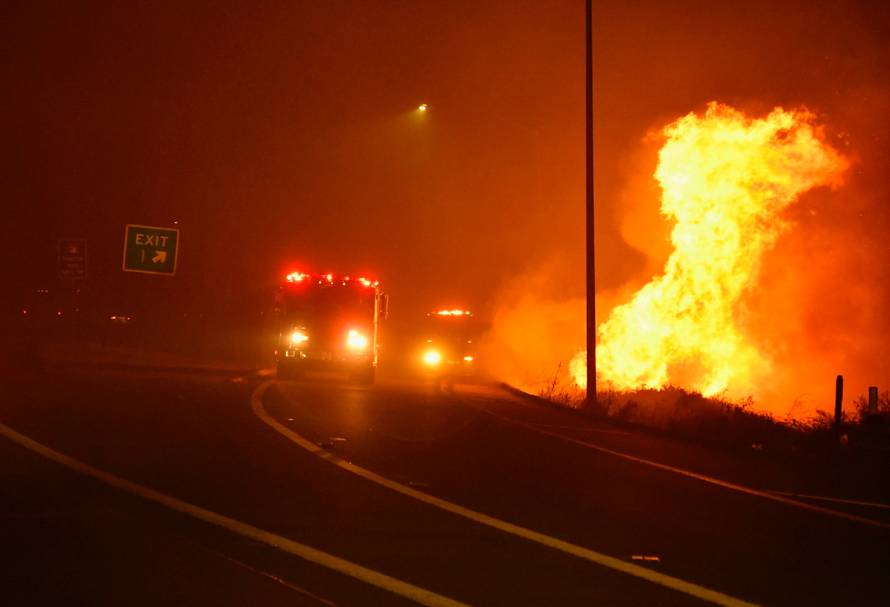 Firefighters arrive to help fight a wind-driven wildfire in Sylmar, California