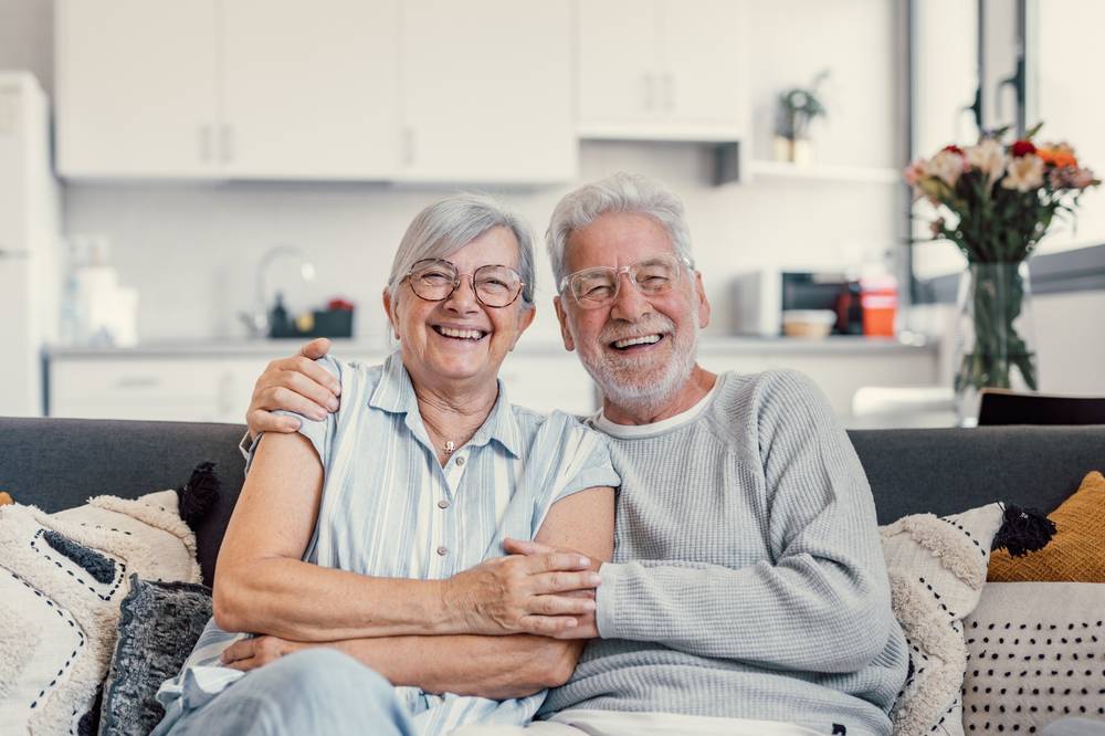 Happy,Mature,Husband,And,Wife,Sit,Rest,On,Couch,At