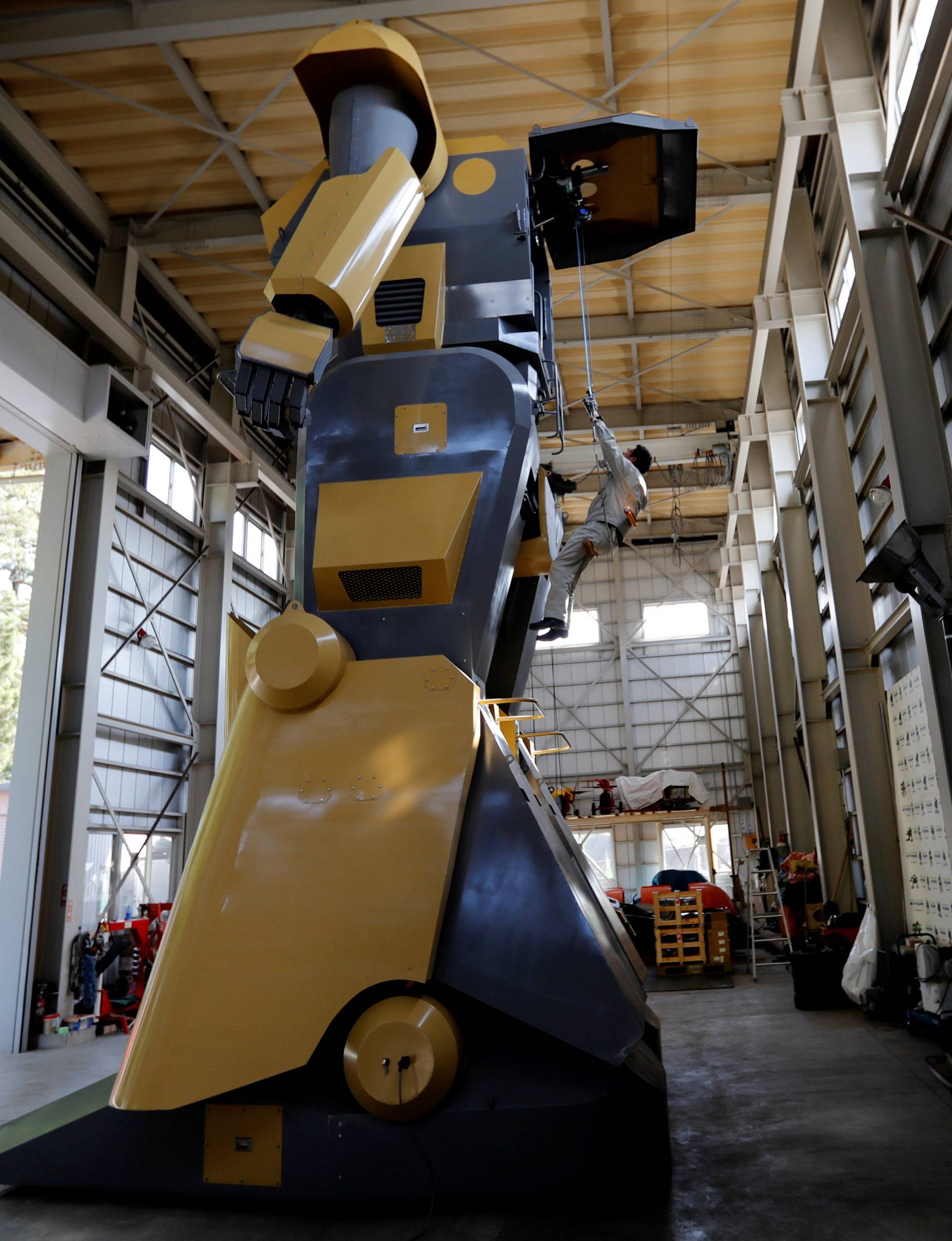 Sakakibara Kikai's engineer Masaaki Nagumo rides a lift to board the bipedal robot Mononofu during its demonstration at its factory in Shinto Village