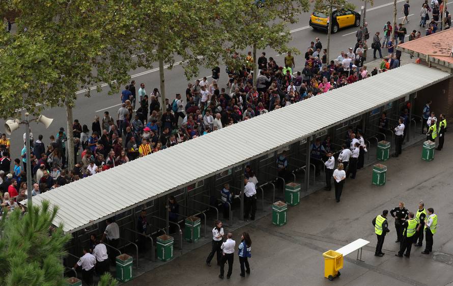 People wait outside Camp Nou stadium for news on whether the Spanish La Liga soccer match between Barcelona and Las Palmas will go ahead as planned in Barcelona