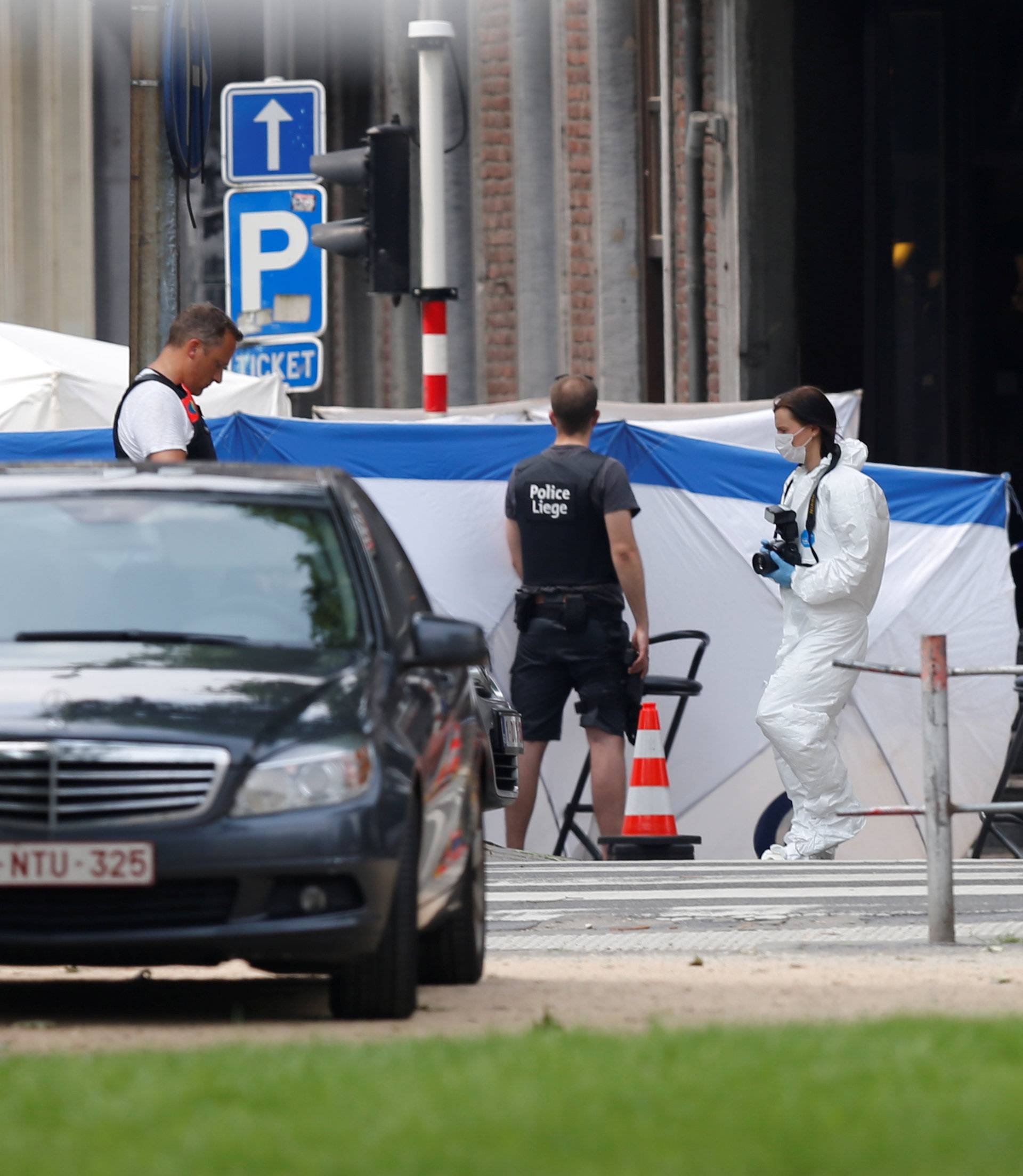 Police officers and forensics experts are seen on the scene of a shooting in Liege