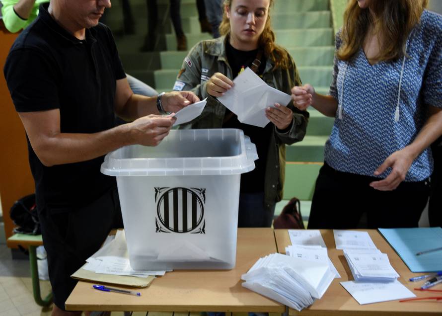 Poll workers count ballots after polls closed at a polling station for the banned independence referendum in Barcelona