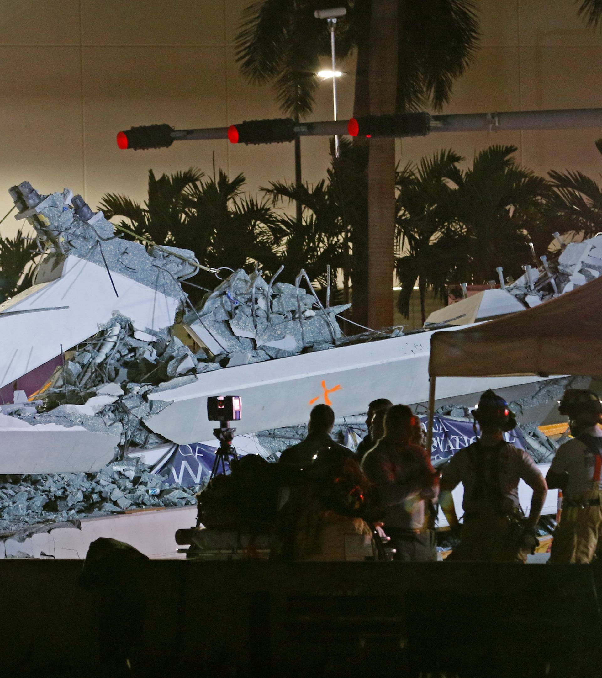 First responders are shown as rescue efforts continue after a pedestrian bridge collapsed at Florida International University in Miami, Florida
