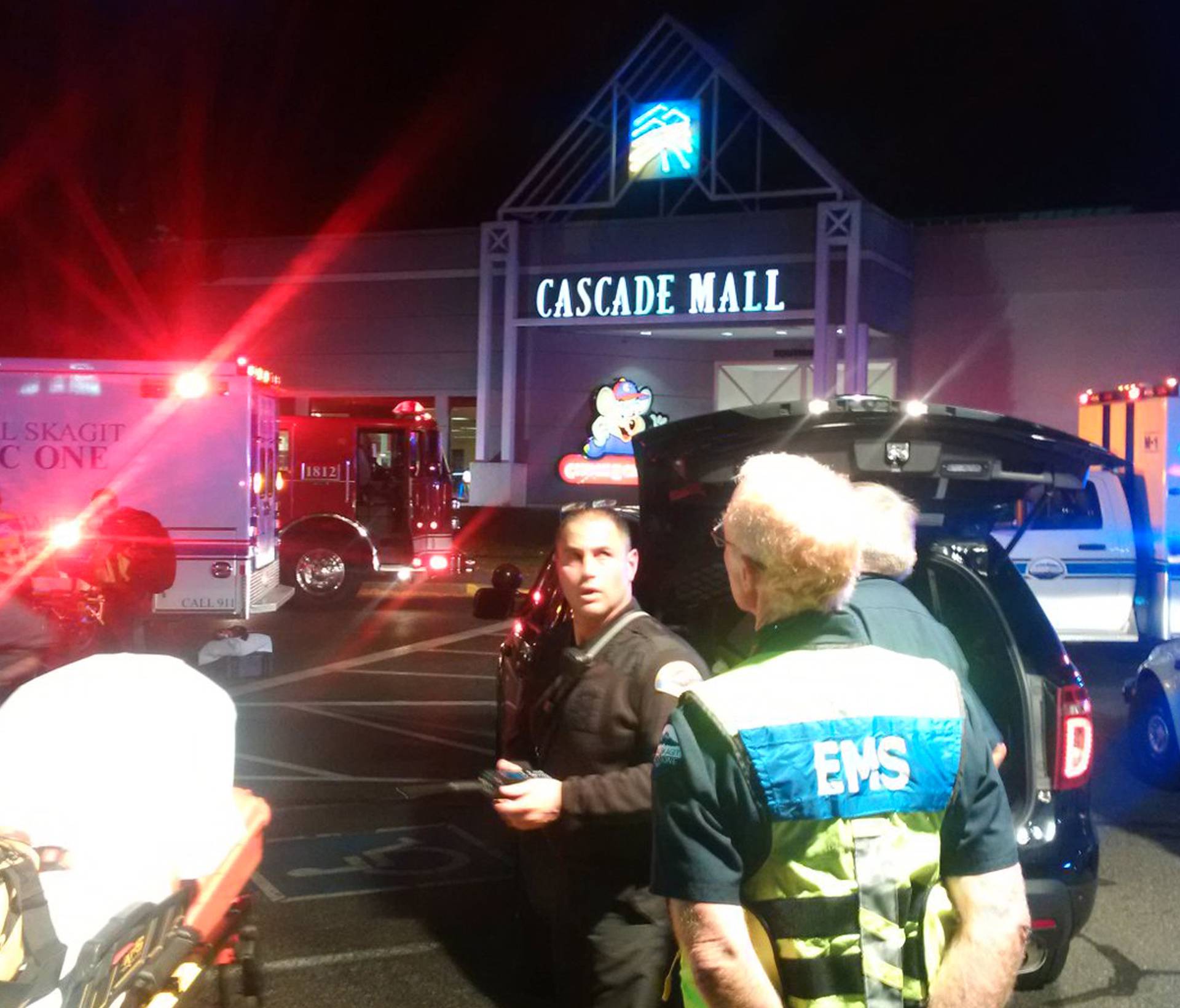 Medics wait to gain access to the Cascade Mall after four people were shot dead in Burlington