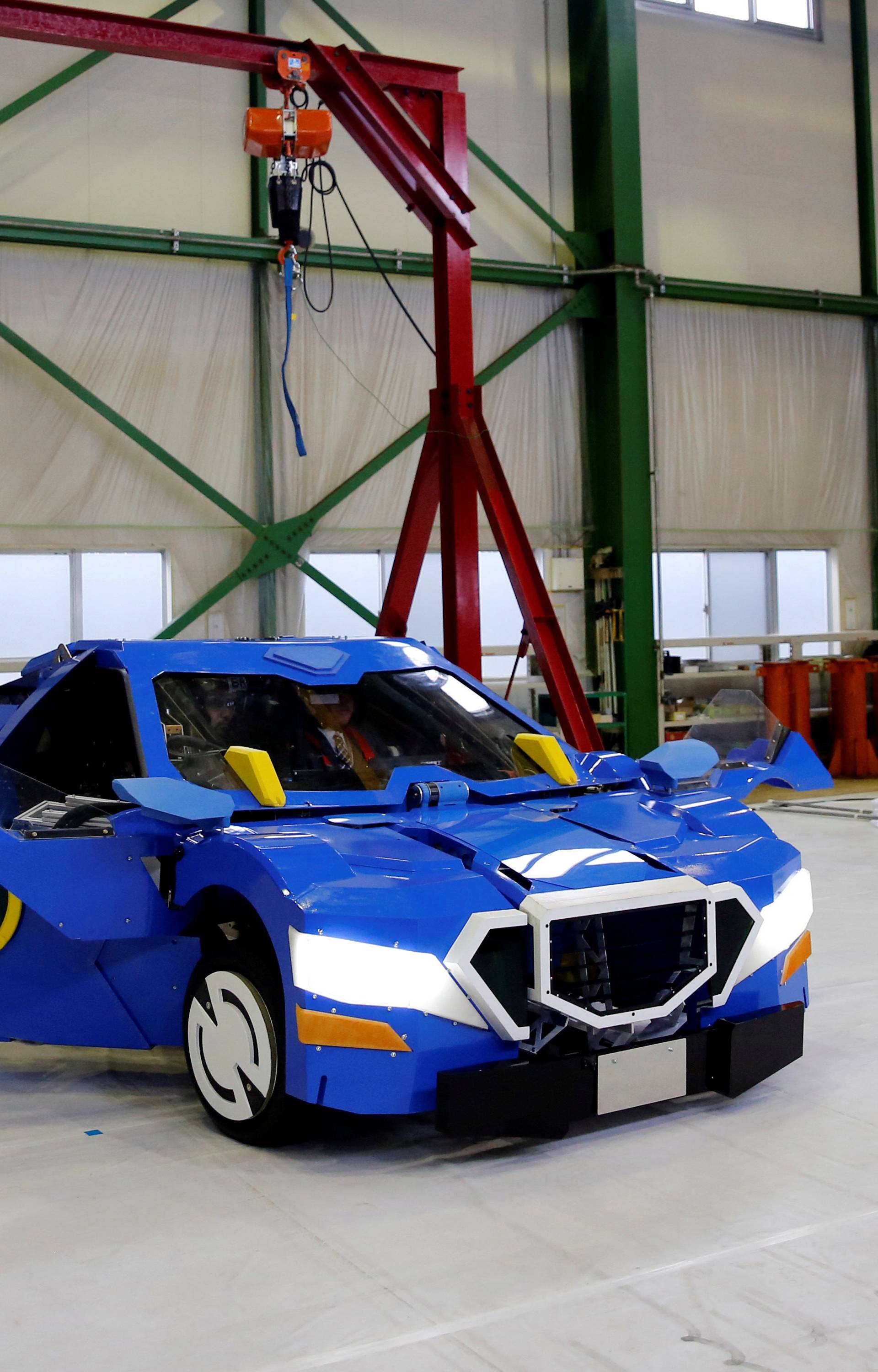 A new transforming robot called "J-deite RIDE" that transforms itself into a passenger vehicle, developed by Brave Robotics Inc, Asratec Corp and Sansei Technologies Inc, is demonstrated during its unveiling at a factory near Tokyo