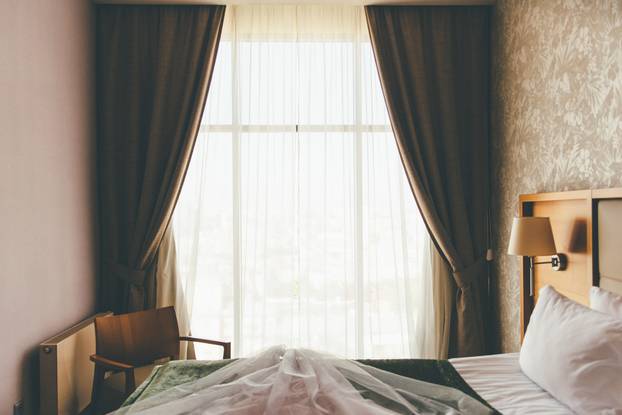 Hotel double bed with wedding dress laying on top