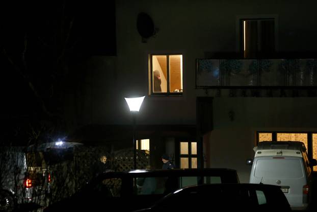 Police are seen in front of a house where six people were found dead in Boeheimkirchen