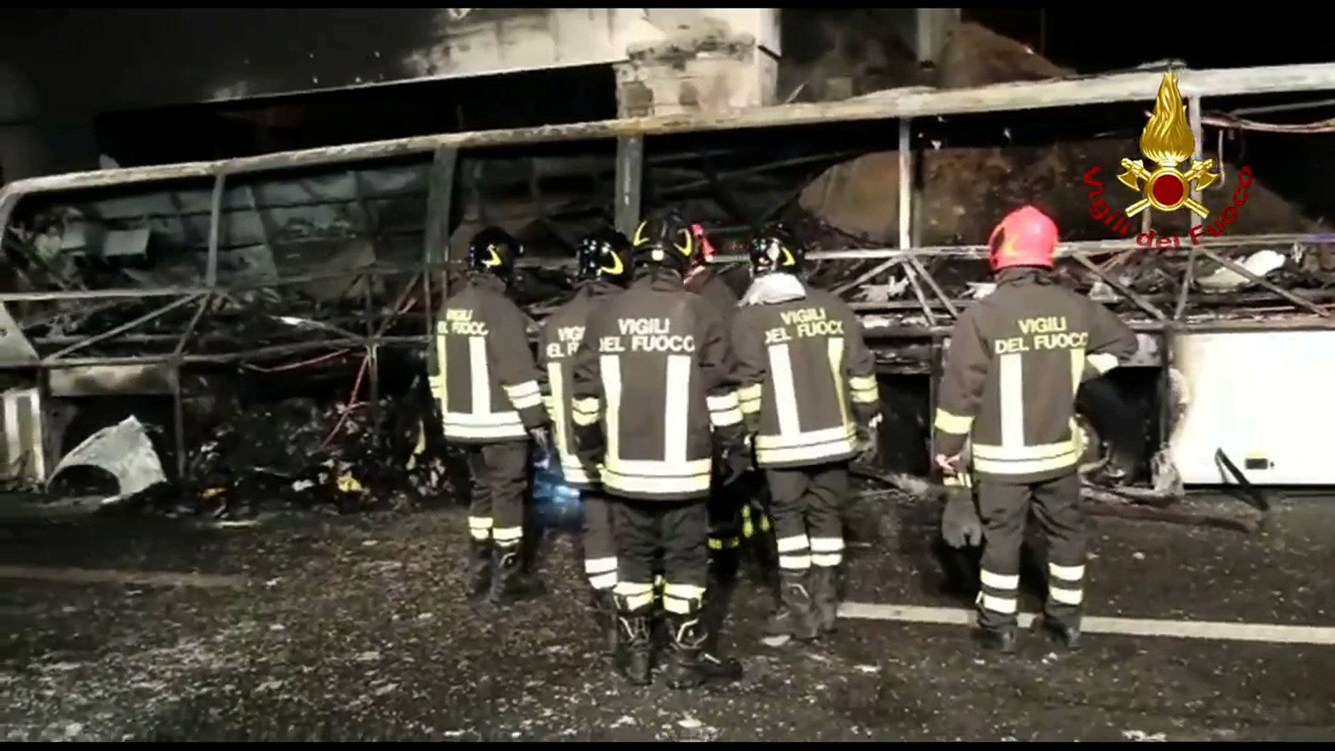 A still image taken from a video shows firefighters working next to a charred bus, which was carrying Hungarian students near Verona
