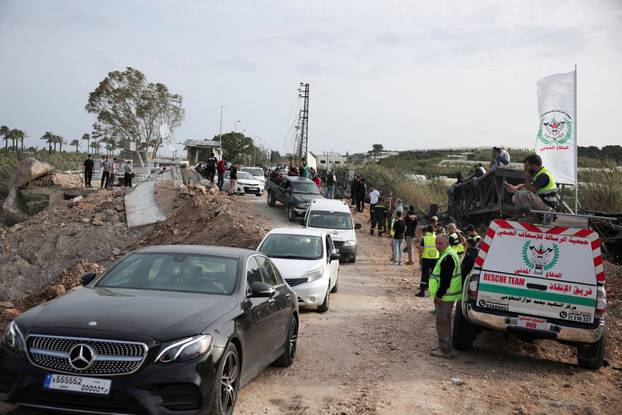 Displaced people cross the bridge linking southern Lebanon to the rest of the country, which was hit earlier in an Israeli strike, in Qasmiyeh