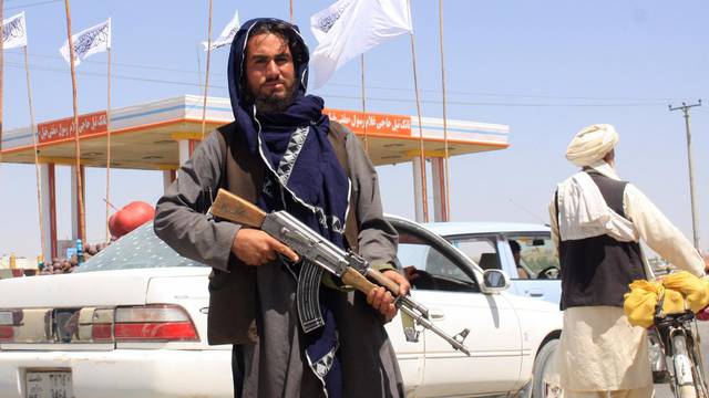 A Taliban fighter looks on as he stands at the city of Ghazni