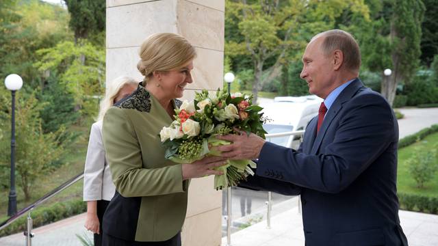 Russian President Vladimir Putin presents flowers to Croatian President Kolinda Grabar-Kitarovic during their meeting at the Bocharov Ruchei state residence in Sochi