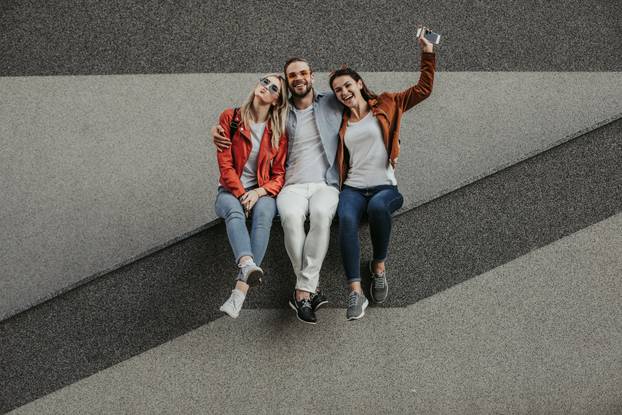 Hilarious laughing friends are sitting on apron