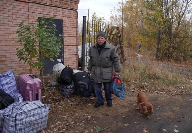 Local man with a dog waits for an evacuation from the frontline town of Kupiansk