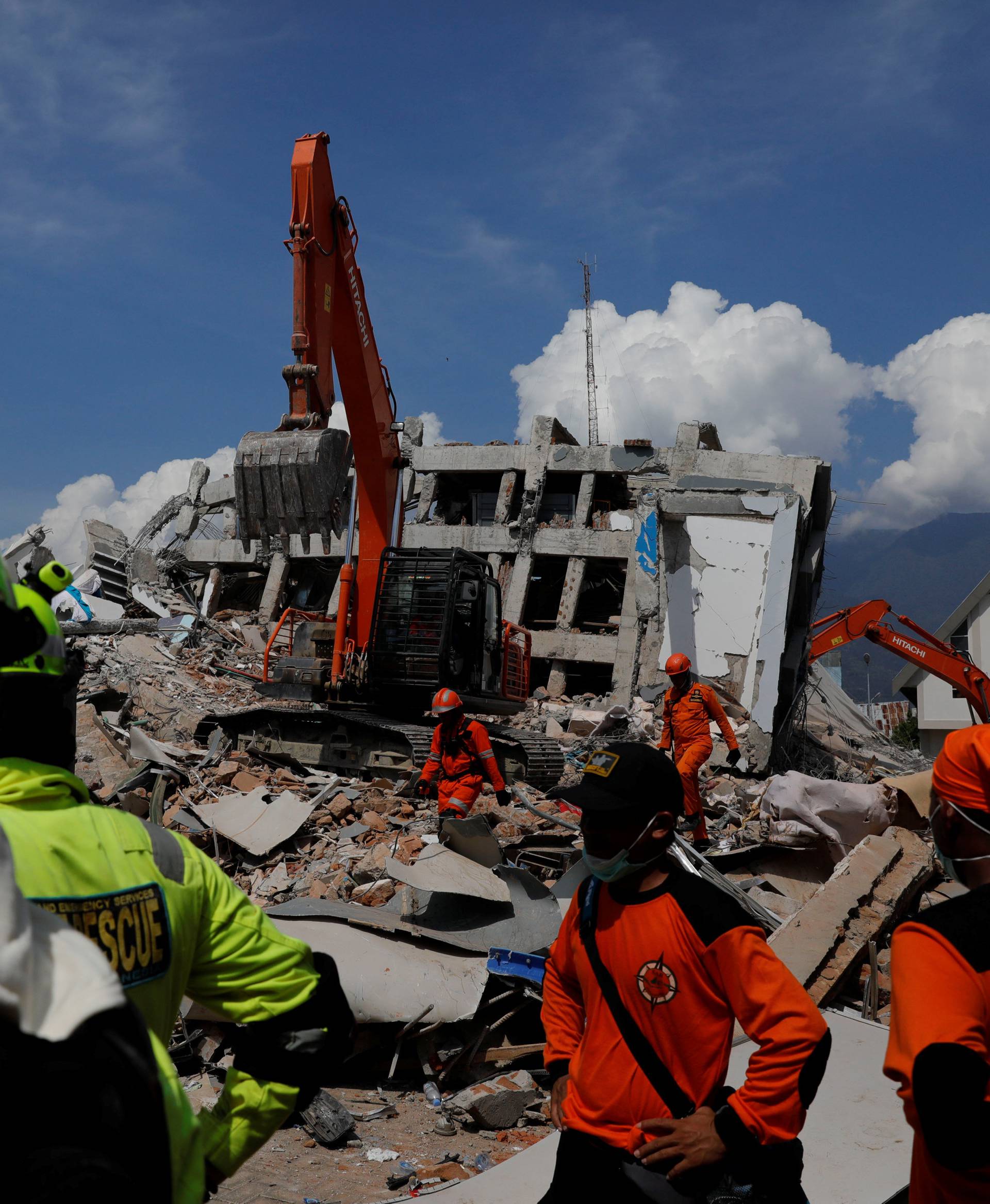 Rescue team members work among the ruins of Roa-Roa hotel after the earthquake in Palu
