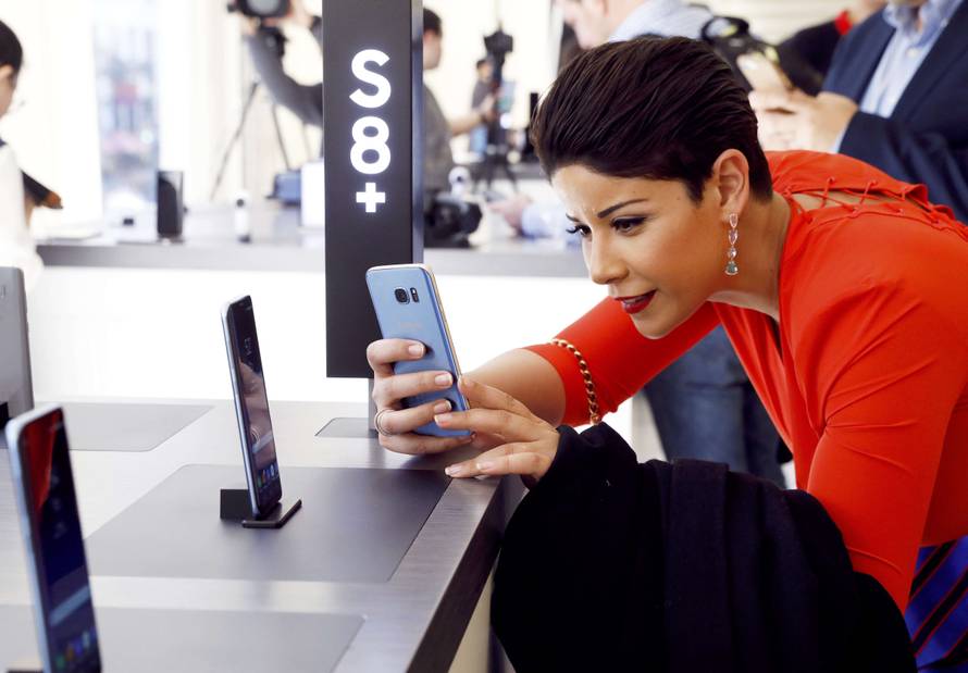 A woman takes a picture of the Samsung Galaxy S8+ smartphone at the introduction of the Galaxy S8 and S8+ smartphones during the Samsung Unpacked event in New York City