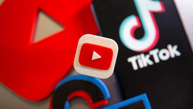 A 3D printed Youtube and Tik Tok logos are seen near smartphone with displayed Tik Tok logo in this illustration taken