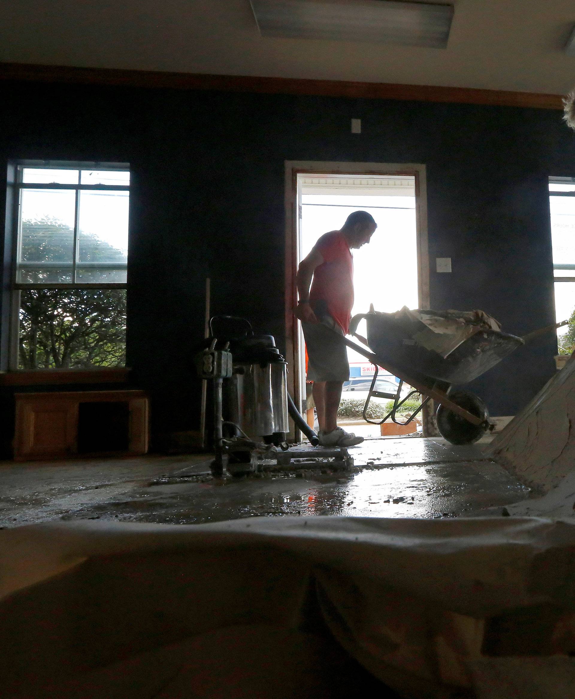 Sharon Bogan and her son Kevin remove drywall from their flooded business in Denham Springs