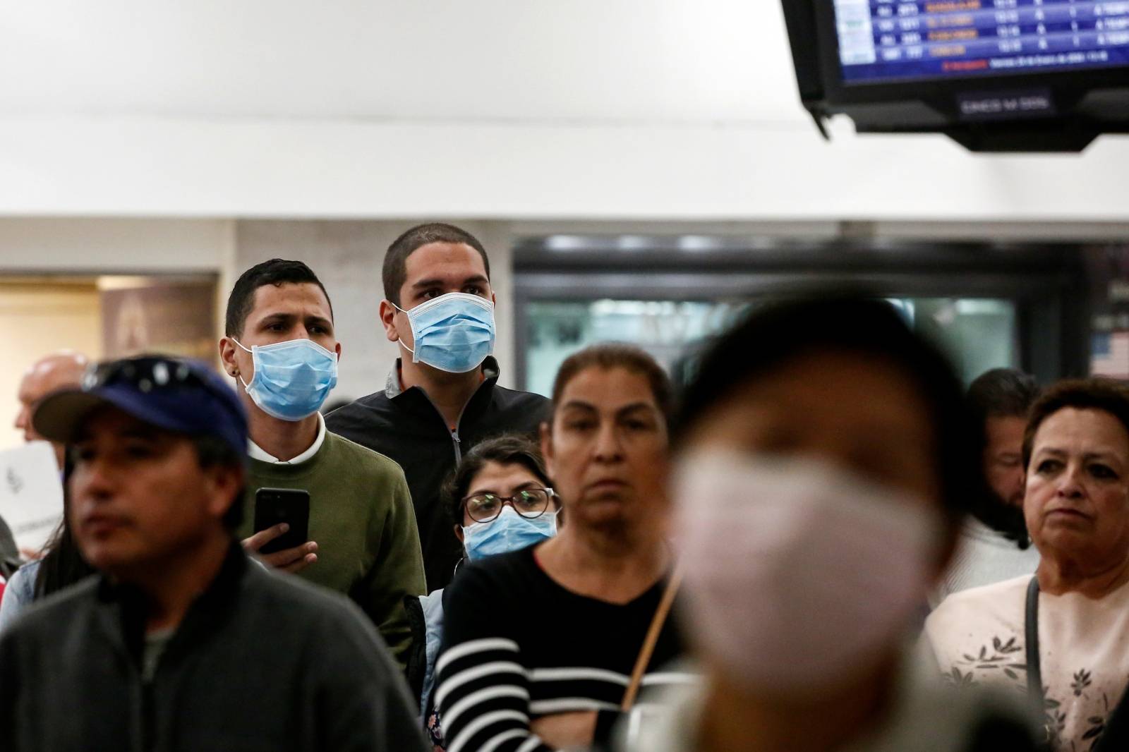 Raphael Hidalgo and his friends wear surgical mask as a preventive measure in light of the coronavirus outbreak in China, at Benito Juarez international airport in Mexico City