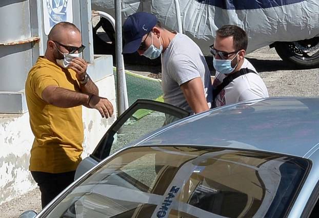 The man with blue cap who is believed to be Manchester United captain Harry Maguire, is escorted by plain-clothes police officers to the police station of the island of Syros, Greece