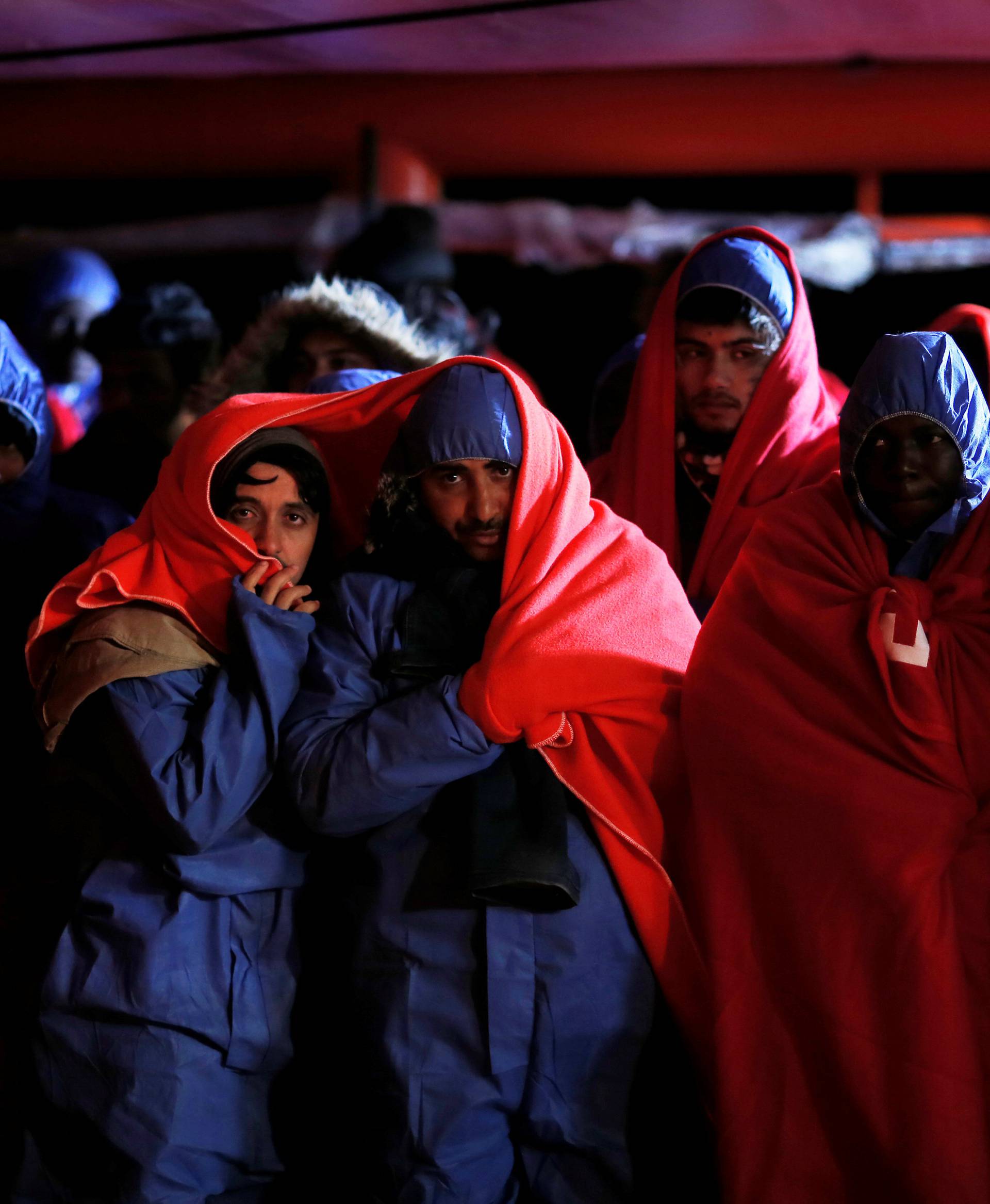 Migrants wait to disembark from a rescue boat at the port of Malaga
