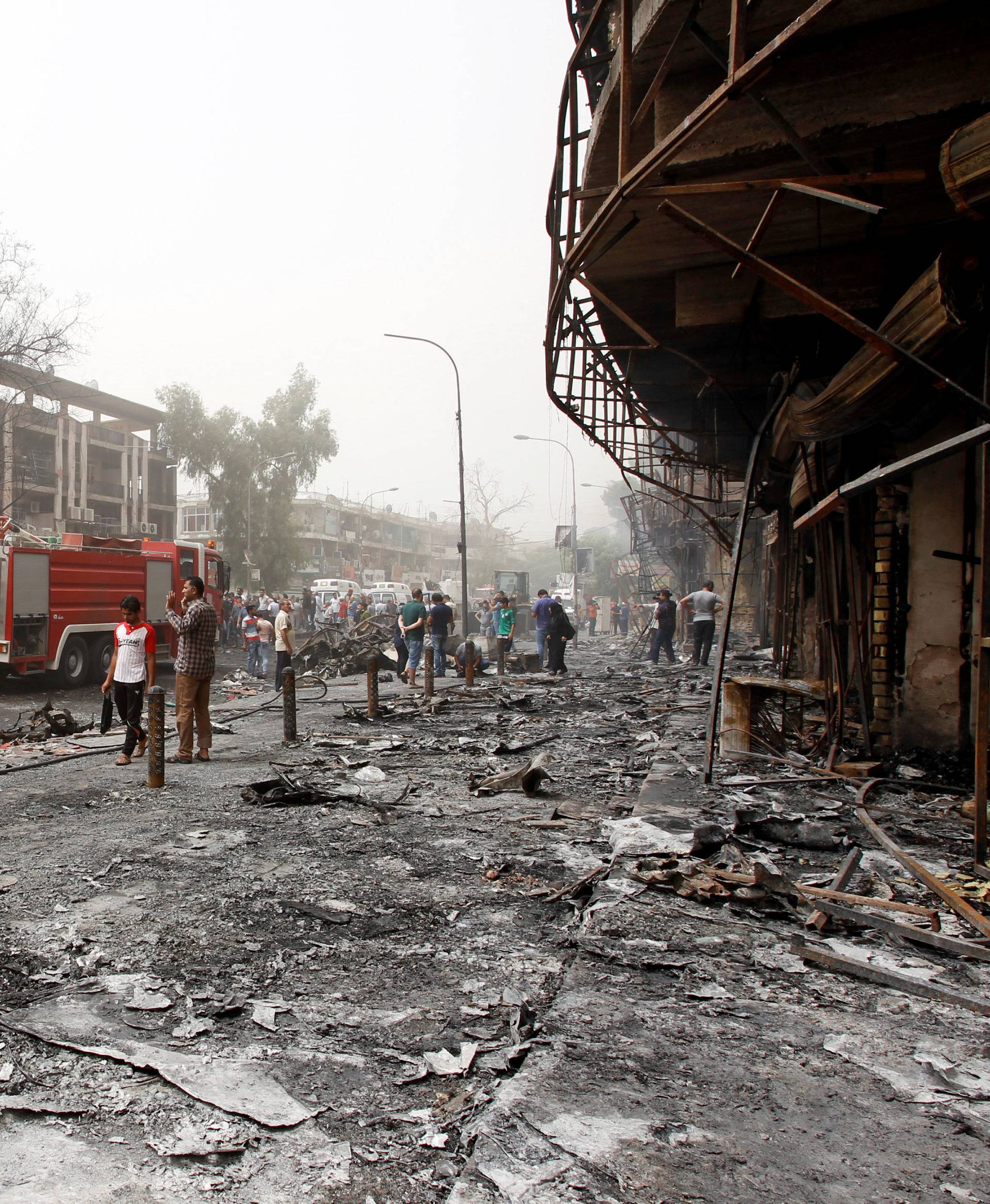 Iraqi security forces and civilians gather at the site after a suicide car bomb occurred in the Karrada shopping area, in Baghdad, Iraq 