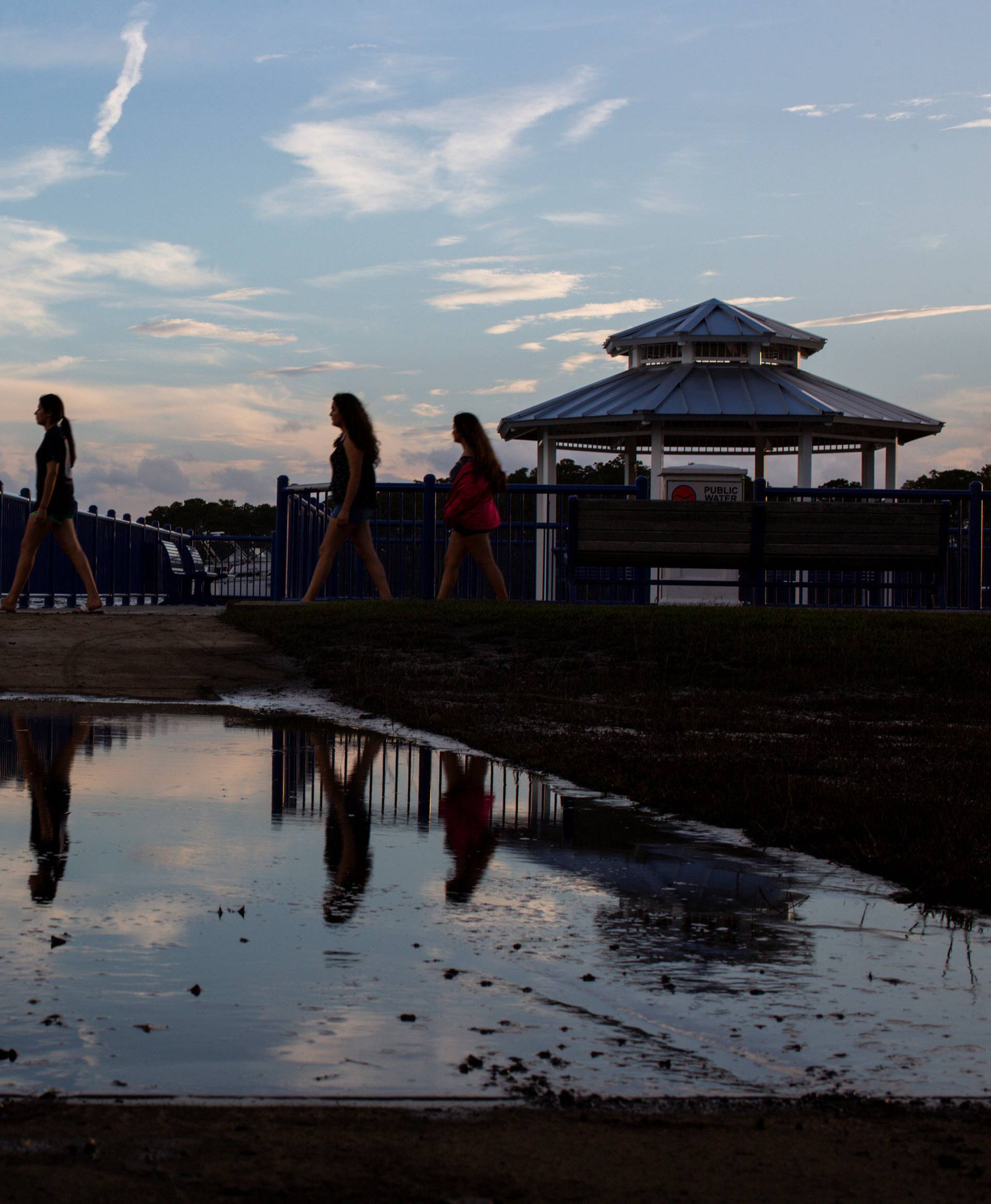 People walk along the walkboard during the sun set after the pass of Hurricane Florence, now downgraded to a tropical depression in Washington, North Carolina