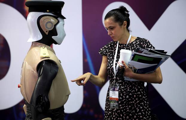 Visitor looks at an operational robot policeman at the opening of the 4th Gulf Information Security Expo and Conference (GISEC) in Dubai
