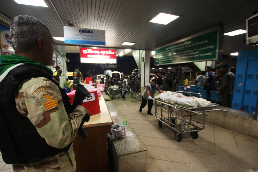 Rescue workers push stretcher trolleys carrying the bodies of dead village defence volunteers, who were killed by suspected separatist insurgents, at a hospital in Yala province