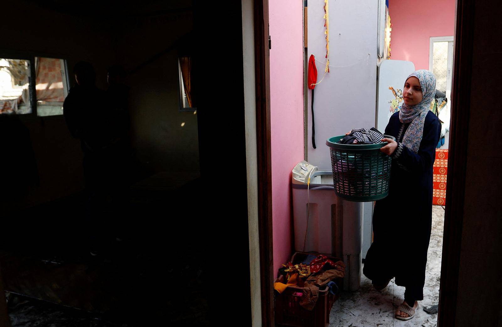 A Palestinian girl returns to her home, which was damaged in an Israeli strike during Israel-Gaza fighting, after a ceasefire was agreed between Palestinian factions and Israel