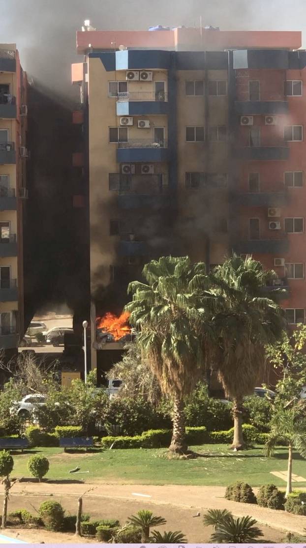 Smoke and fire rise from an apartment building in a residential complex, in Khartoum