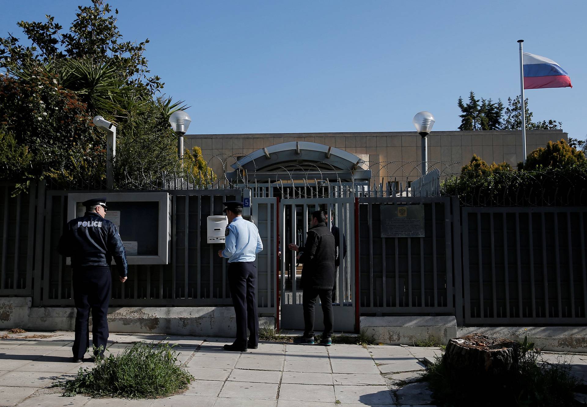 Police officers stand outside the Russian consulate after an explosion, in Athens