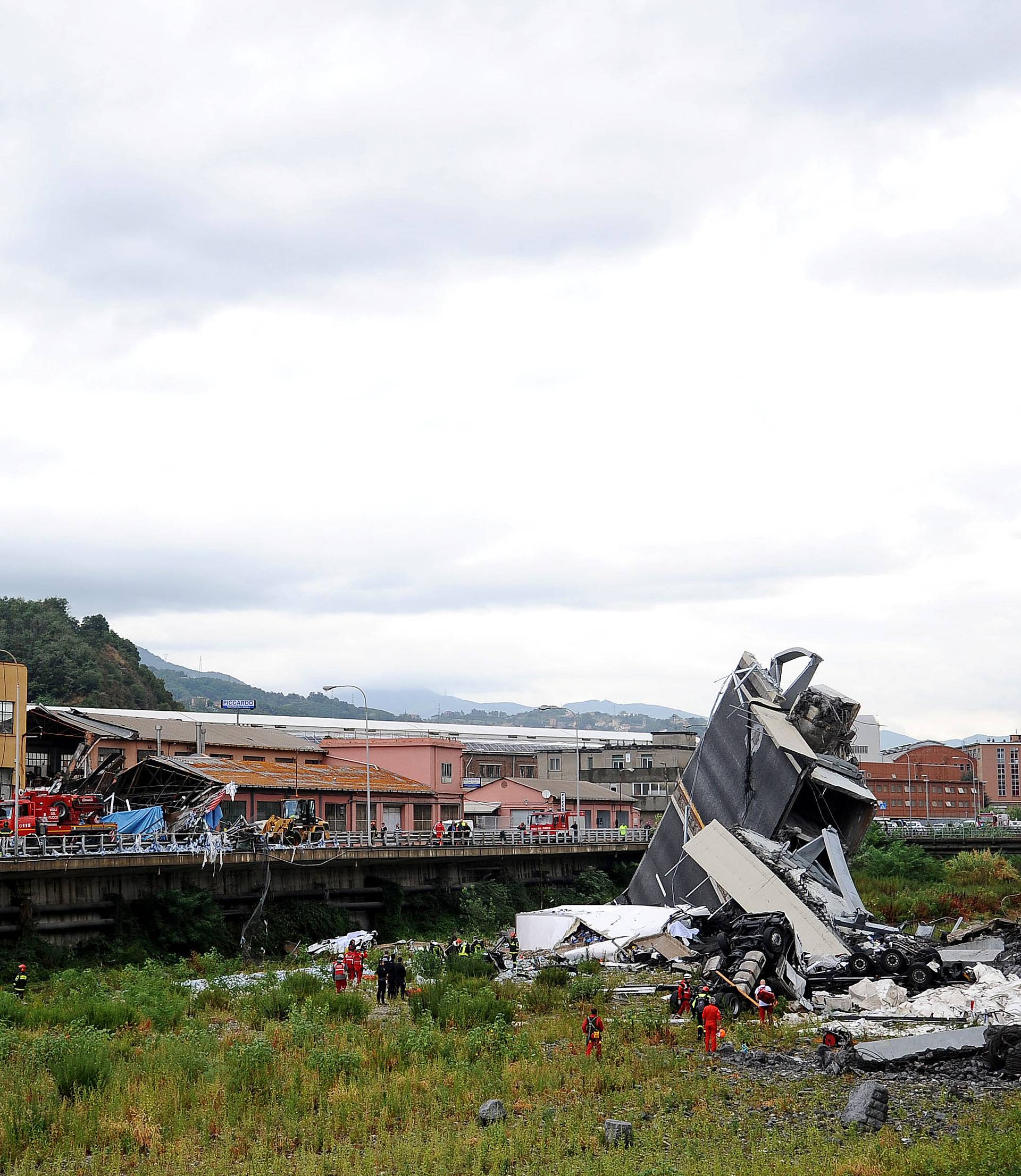 Rescue workers are seen at the collapsed Morandi Bridge in the Italian port city of Genoa