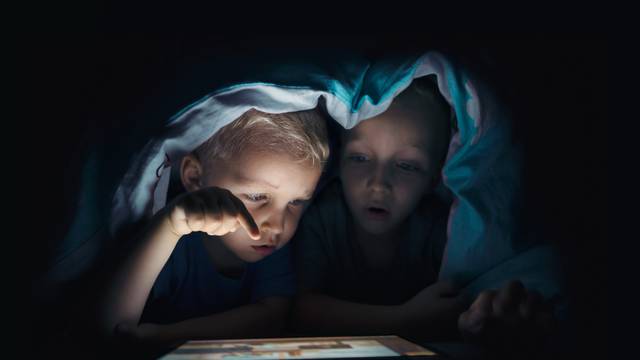 Two,Kids,With,Tablet,Computer,In,A,Dark,Room.,Protection