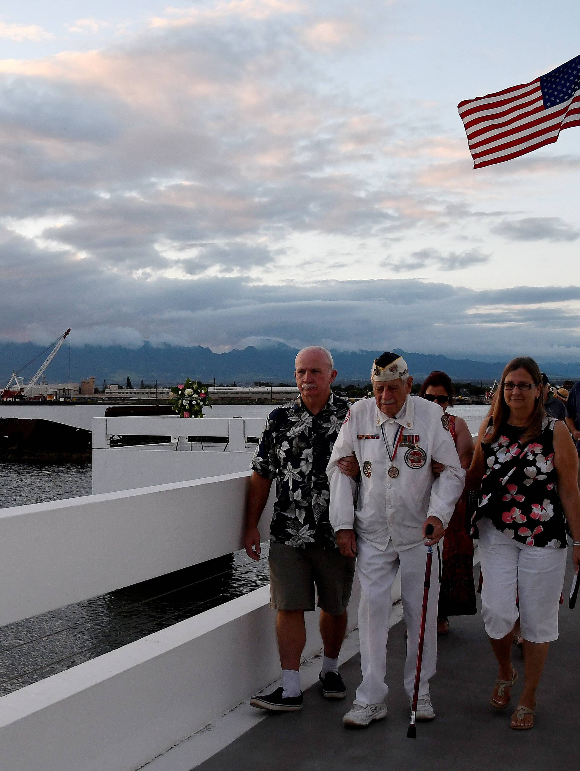 Pearl Harbor survivor Delton Walling walks with family members during a ceremony honoring the sailors of the USS Utah at the memorial on Ford Island at Pearl Harbor in Honolulu, Hawaii