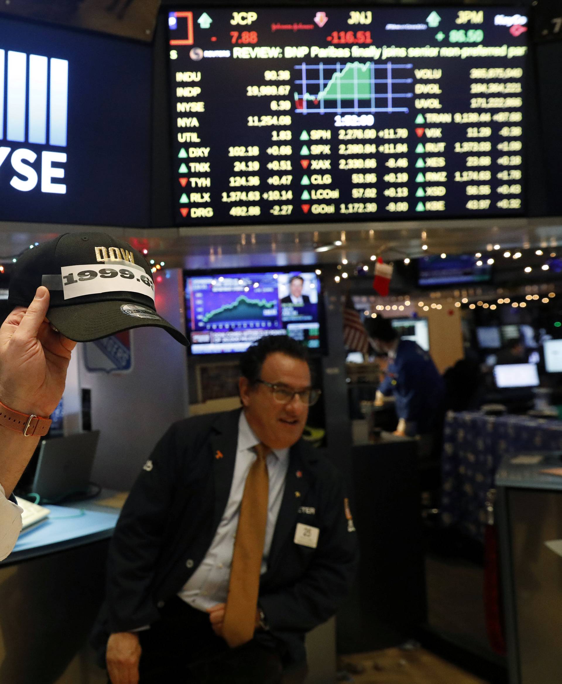 A trader laughs as he holds a hat at NYSE