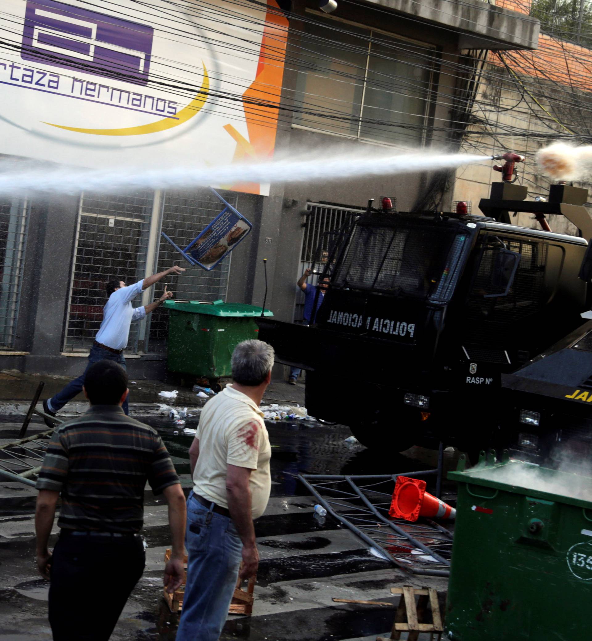 Protestors fight with the police during a demonstration against a possible change in the law to allow for presidential re-election in front of the Congress building in Asuncion