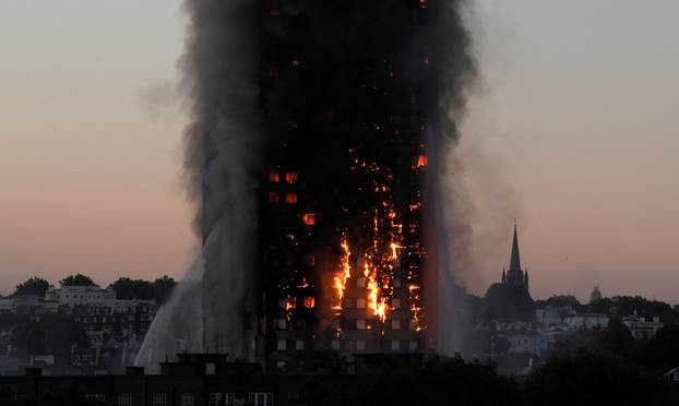 Flames and smoke billow as firefighters deal with a serious fire in the Grenfell Tower apartment block at Latimer Road in West London