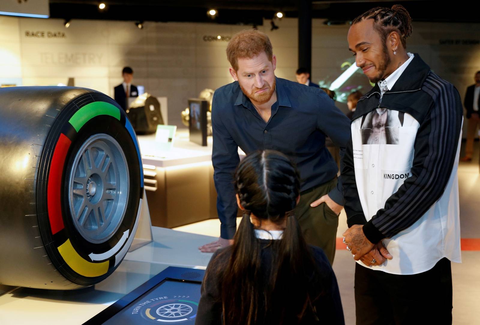 Britain's Prince Harry and Formula One World Champion Lewis Hamilton talk to school children as they visit Silverstone circuit, in Towcester