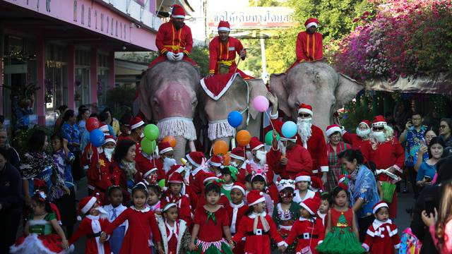 Elephants, teachers and students dressed in Santa Claus costumes parade during Christmas celebrations at Jirasart school in Ayutthaya