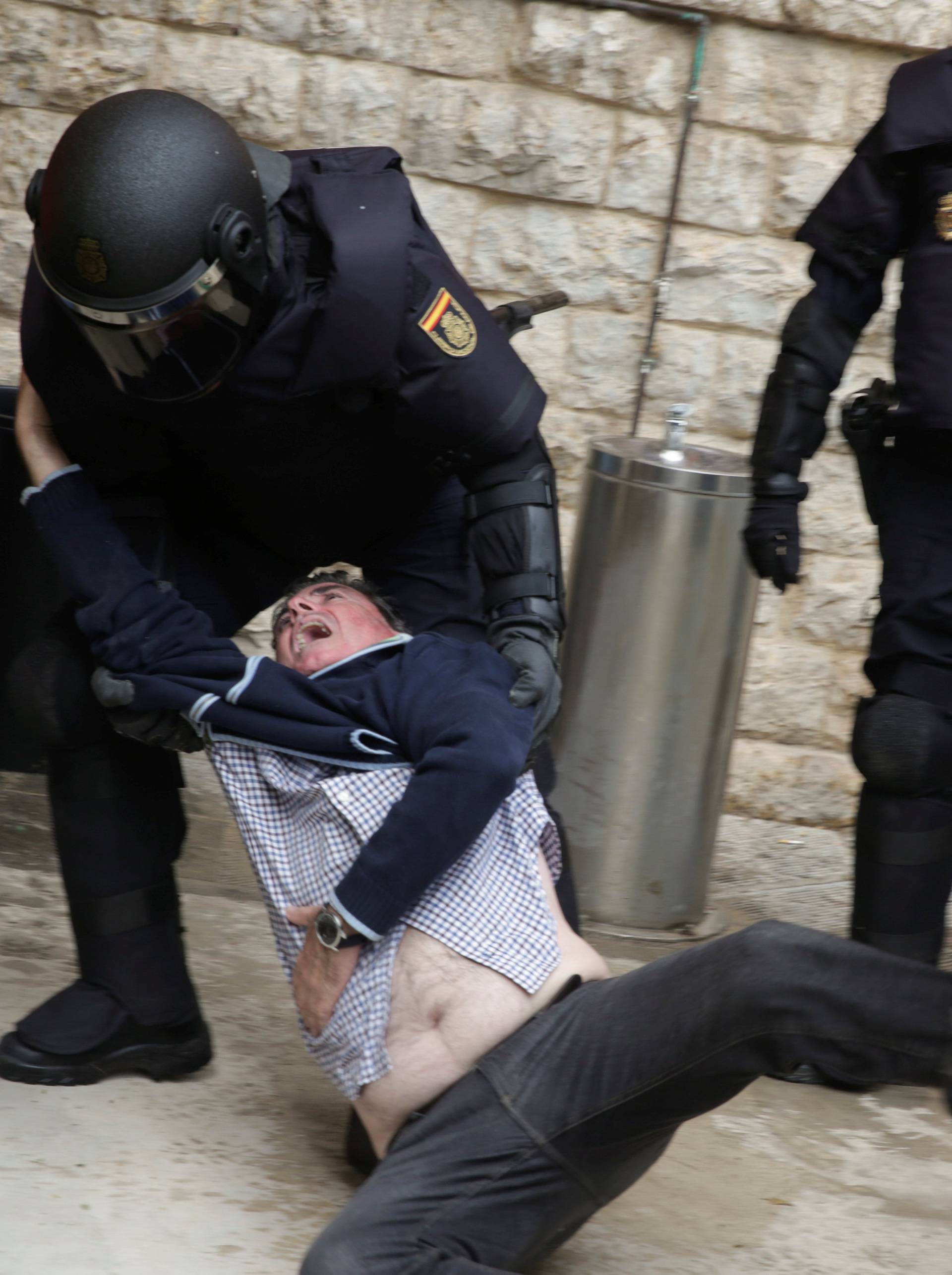 Spanish police scuffle with a man outside a polling station for the banned independence referendum in Tarragona