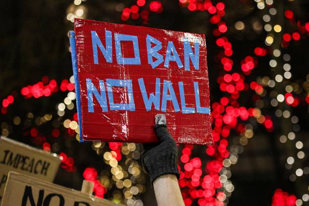 A man holds a sign during a protest held in response to President Donald Trump