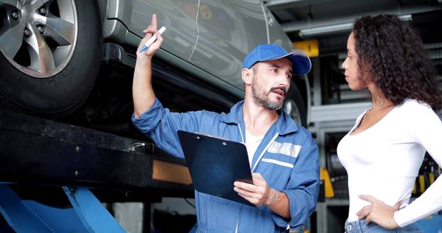 Automotive,Mechanic,Man,In,Uniform,Explaining,Checklist,Car,Maintenance,And