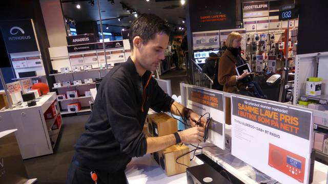 Worker Nilsen arranges digital radios in an Expert City electronics shop in Oslo