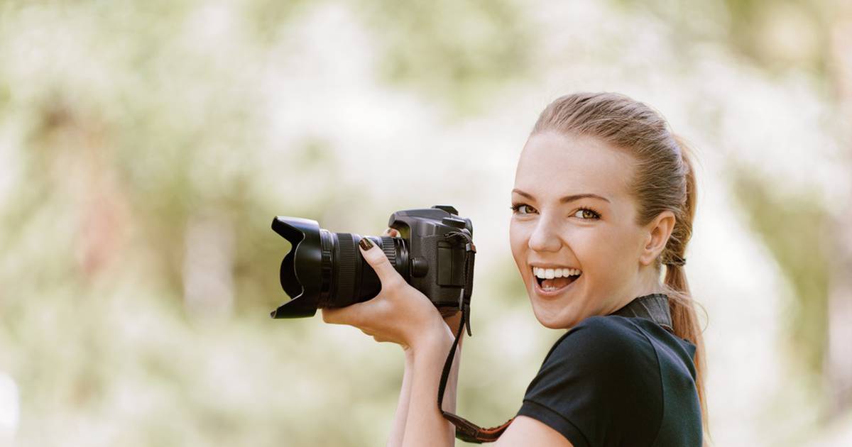 Фотограф создает. Профессиональный фотограф девушка. Улыбающаяся женщина с фотоаппаратом. Снимки на профессиональный фотоаппарат. Фотограф фотографирует девушку.