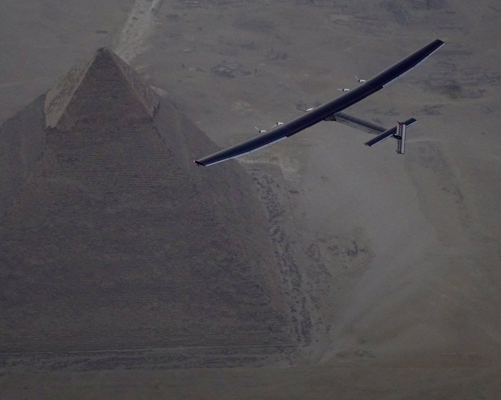 Solar Impulse 2, the solar powered plane, piloted by Swiss pioneer Andre Borschberg is seen during the flyover of the pyramids of Giza on July 13, 2016 prior to the landing in Cairo