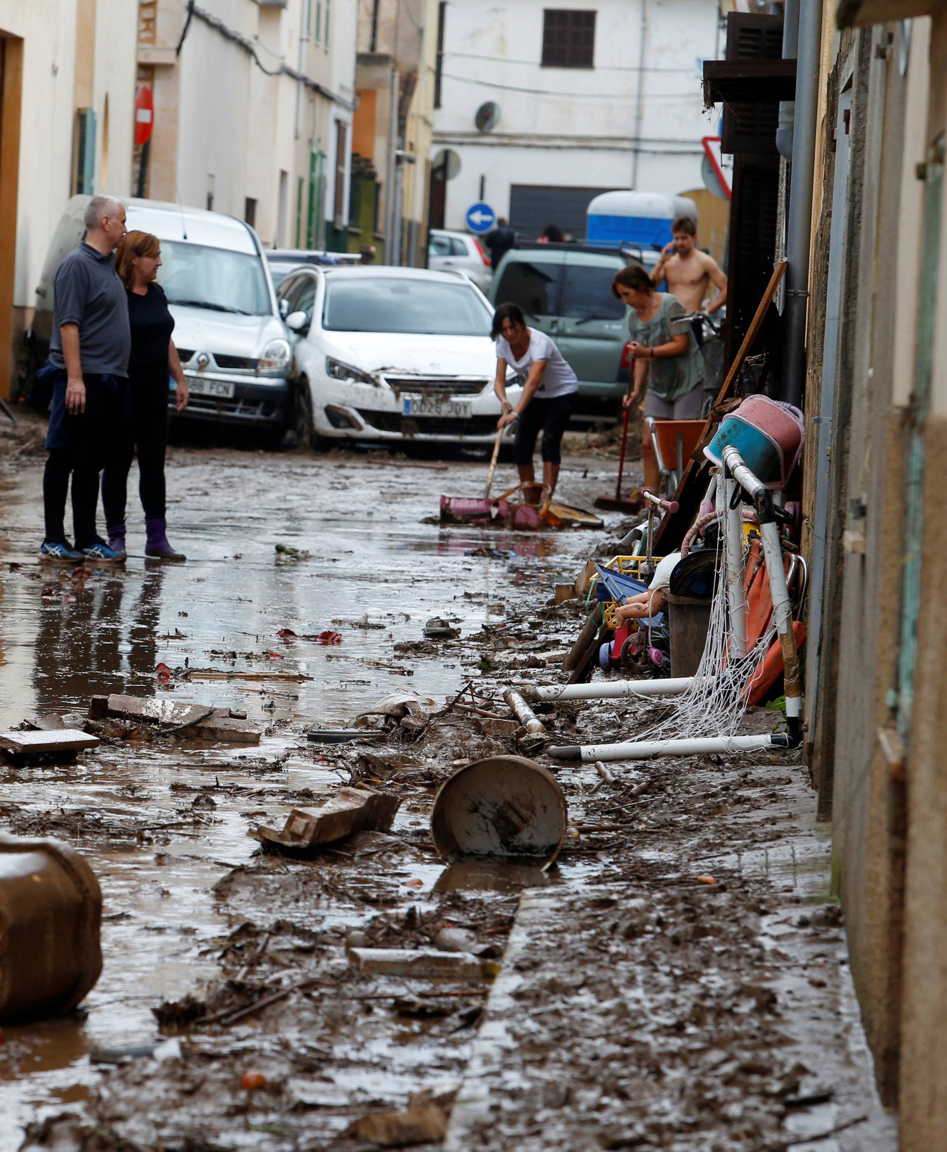 People clean the debris as heavy rain and flash floods hit Sant Llorenc de Cardassar on the island of Mallorca